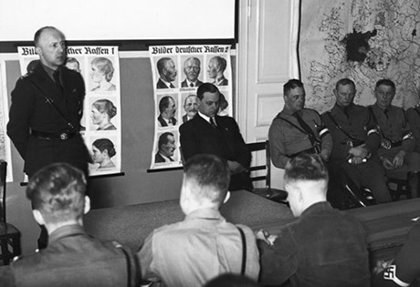 Helmut Stellrecht, till vänster, talar till ledare inom Hitlerjugend. Bredvid honom till höger sitter Alfred Rosenberg.