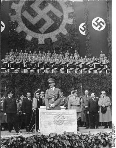 Adolf Hitler lägger grundstenen till Volkswagenverk den 26 maj 1938. Längst till höger i bilden syns Ferdinand Porsche.