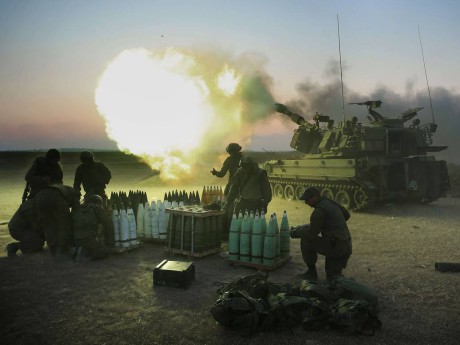 Israeliska soldater med en 155 mm artillerikanon avfyrar pjäser mot Gazaremsan, från deras position nära den israeliska gränsen. 